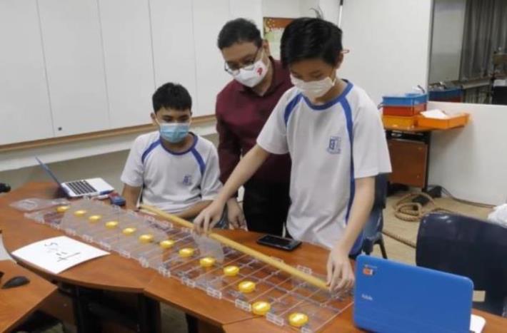 Yusof Ishak Secondary School students using a wave simulator demo kit in class, under the supervision of Lead Teacher (Physics) Mr Donavan Lau.