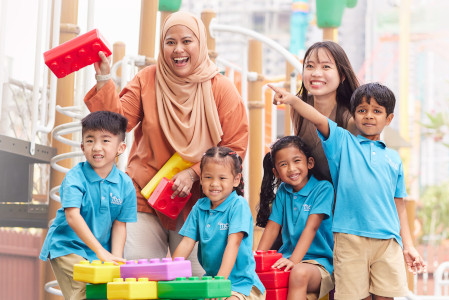 Kindergarten teacher surrounded by a group of young children