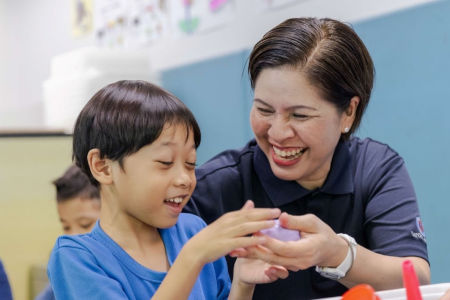Teacher smiles and guides the student